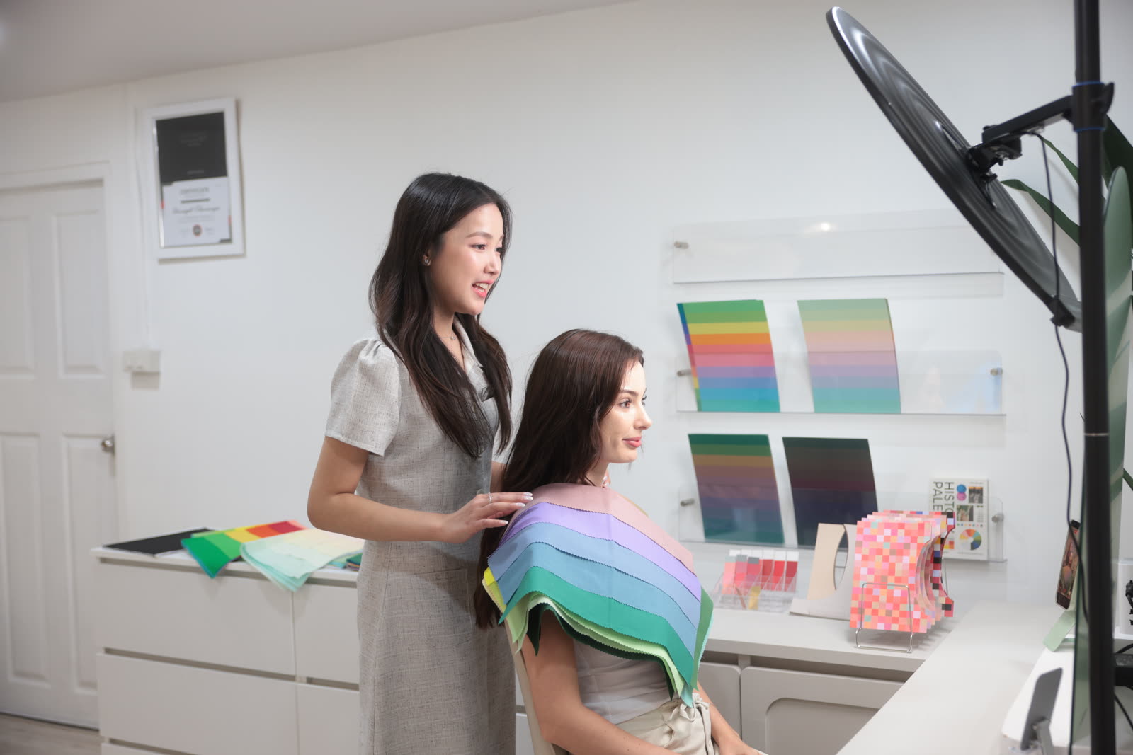 Consultant draping color fabric over a client's shoulders during a session